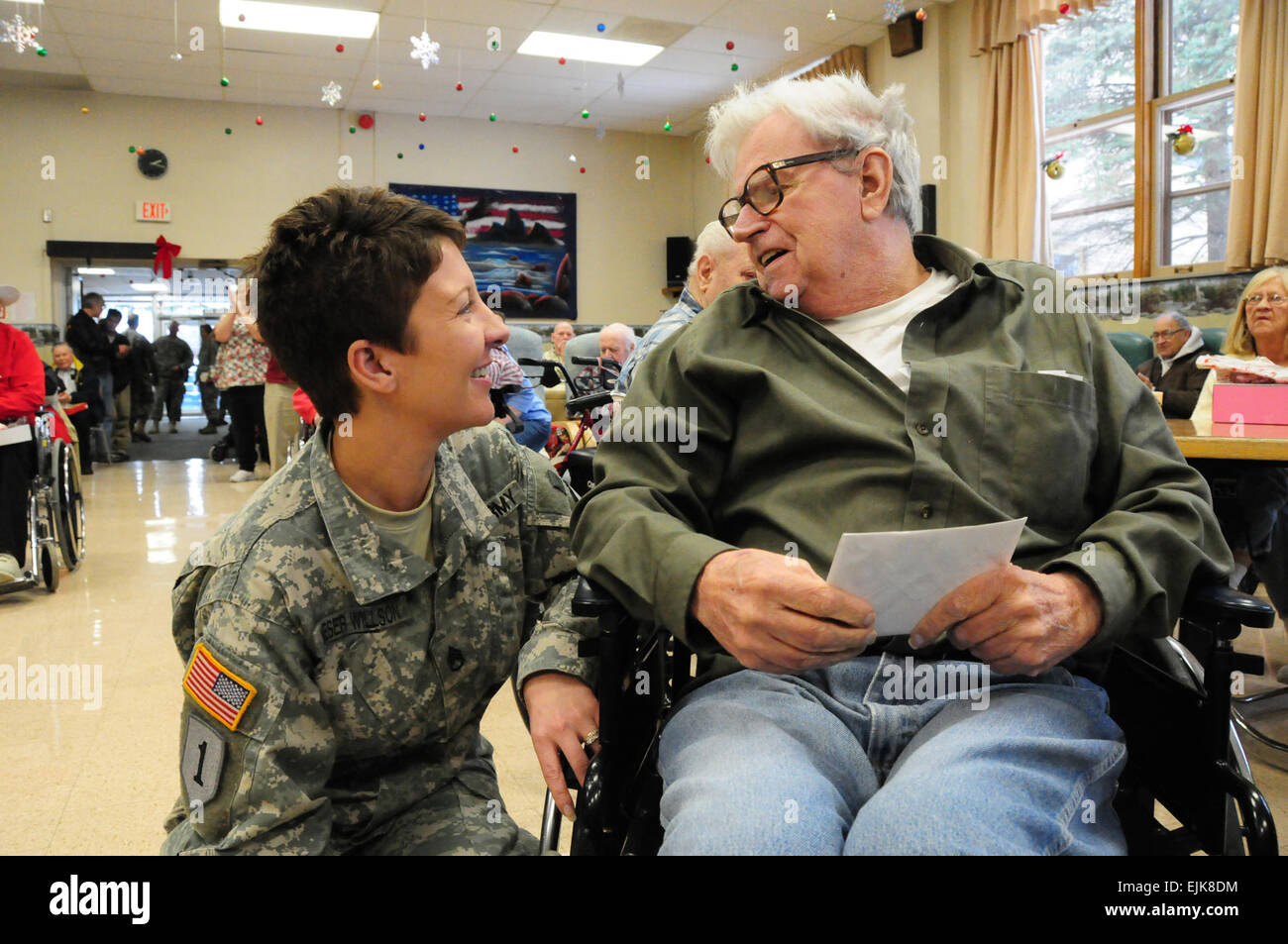 US Army Staff Sgt Amy Wieser Willson, links, mit der 231st Brigade Support Battalion, North Dakota National Guard, besucht ein Bewohner von North Dakota Veteranen Haus in Lissabon, N.D., 15. Dezember 2010, während der jährlichen Weihnachtsfeier.  Senior Master Sergeant David H. Lipp Stockfoto