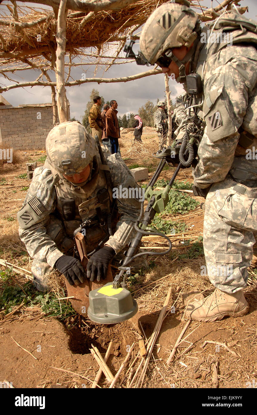 US Army Staff Sgt Matthew Jemison, gräbt als Sgt. Paul Griffin Suche nach versteckten Waffen Caches mit einem Metall positionert nahe einem Dorf südöstlich von Salman Pak, Irak, 15. Februar 2008. Beide Soldaten sind mit Befehl Sicherheitsabteilung, 1. Bataillon, 15. Infanterie-Regiment, 3. Heavy Brigade Combat Team, 3. Infanterie-Division.  Sgt. Timothy Kingston Stockfoto