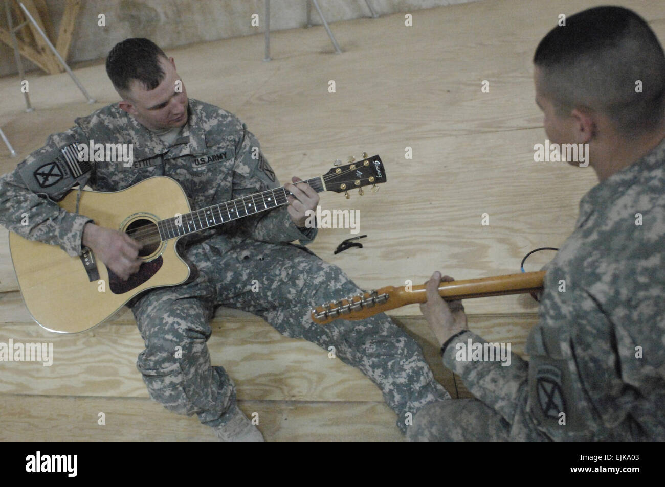 US Army Schutzzertifikate Eric Pettit und Charles Jones, zugewiesen an Hauptsitz Zug, Bravo Batterie, 5. 25. Feldartillerie-Regiment, Bataillon, 4. Brigade, 10th Mountain Division spielen Gitarre zusammen an gemeinsamen Sicherheit Station Babel, Karadah, Bagdad, Irak, 18. März 2008.  Staff Sgt Jason T. Bailey Stockfoto