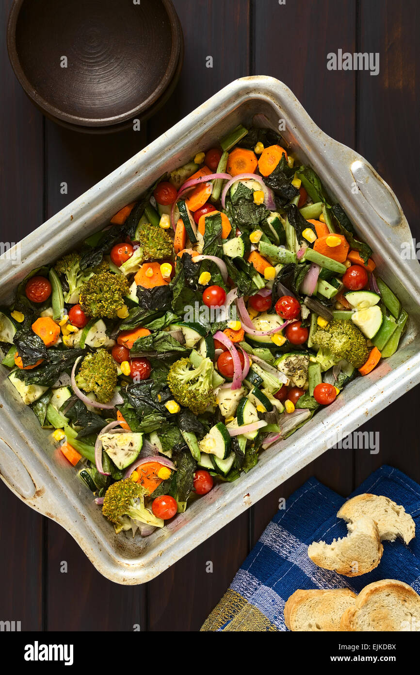 Overhead Schuss gebackenes Gemüse (Zucchini, Zwiebel, Cherry Tomaten, Brokkoli, Karotten, Mais, grüne Bohnen, Mangold) Stockfoto