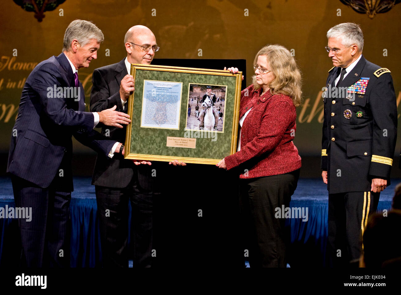 Secretary Of The Army John McHugh, präsentiert eine Gedenktafel Phil Miller, Vater der Ehrenmedaille Empfänger uns staff of the Army Sgt. Robert J. Miller und Mutter Maureen Miller, als Stabschef der Armee General George W. Casey Jr. während einer Zeremonie im Pentagon, 7. Oktober 2010 blickt auf.  Miller wurde posthum die landesweit höchste Auszeichnung für seine Heldentaten in Afghanistan am 25. Januar 2008, nach der Anzeige unermesslichen Mut und ungewöhnlich Tapferkeit schließlich opfert sein Leben, um seinen Teamkollegen und 15 Afghanistan National Army Soldaten retten.  Foto: Verteidigungsministerium Stockfoto