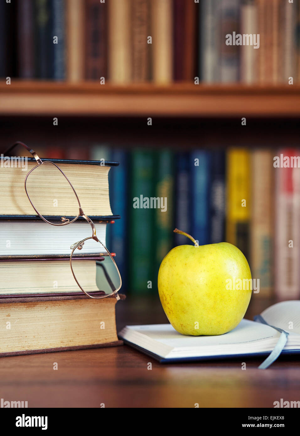 Apfel auf das aufgeschlagene Buch Stockfoto