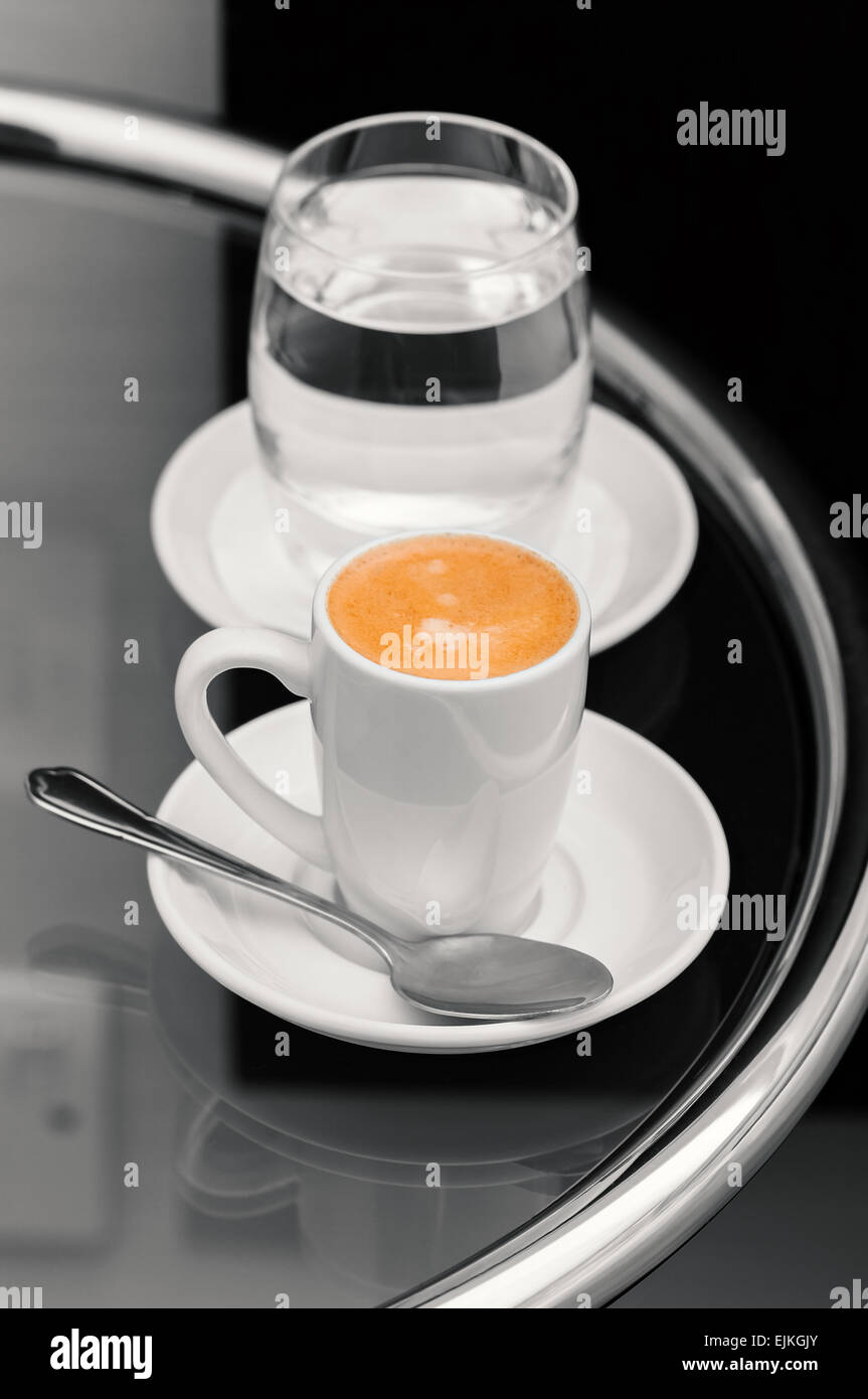 Espresso-Kaffee und ein Glas Wasser am Tisch Stockfoto