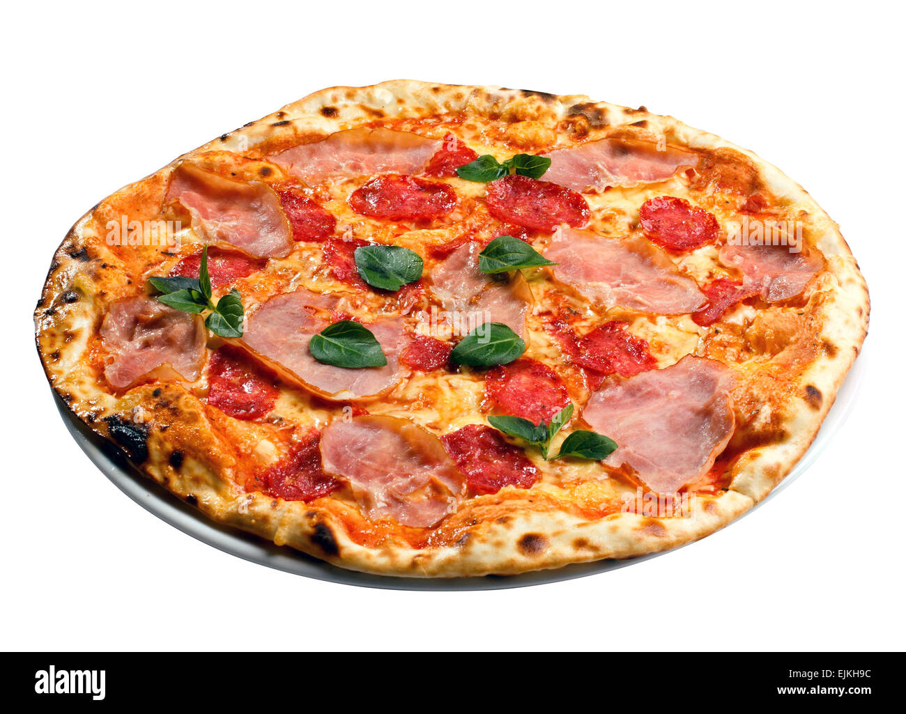 Runde Pizza mit Schinken, Tomaten und grünen Stockfoto