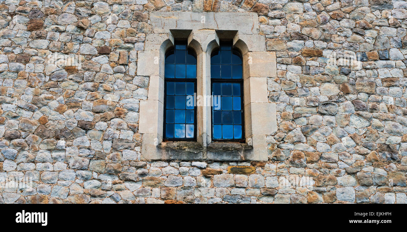 Alten Stein mittelalterlichen Mauer mit zwei Fenstern in Mitte Stockfoto