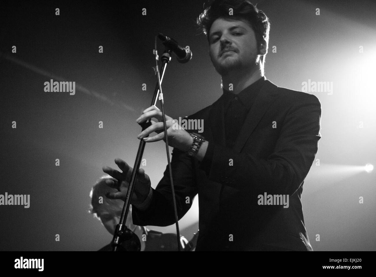 Man stellte zwischen singen in einer Band und schaut direkt in die Kamera fast das Mikrofon zu spielen, als wäre es eine Querflöte. Stockfoto