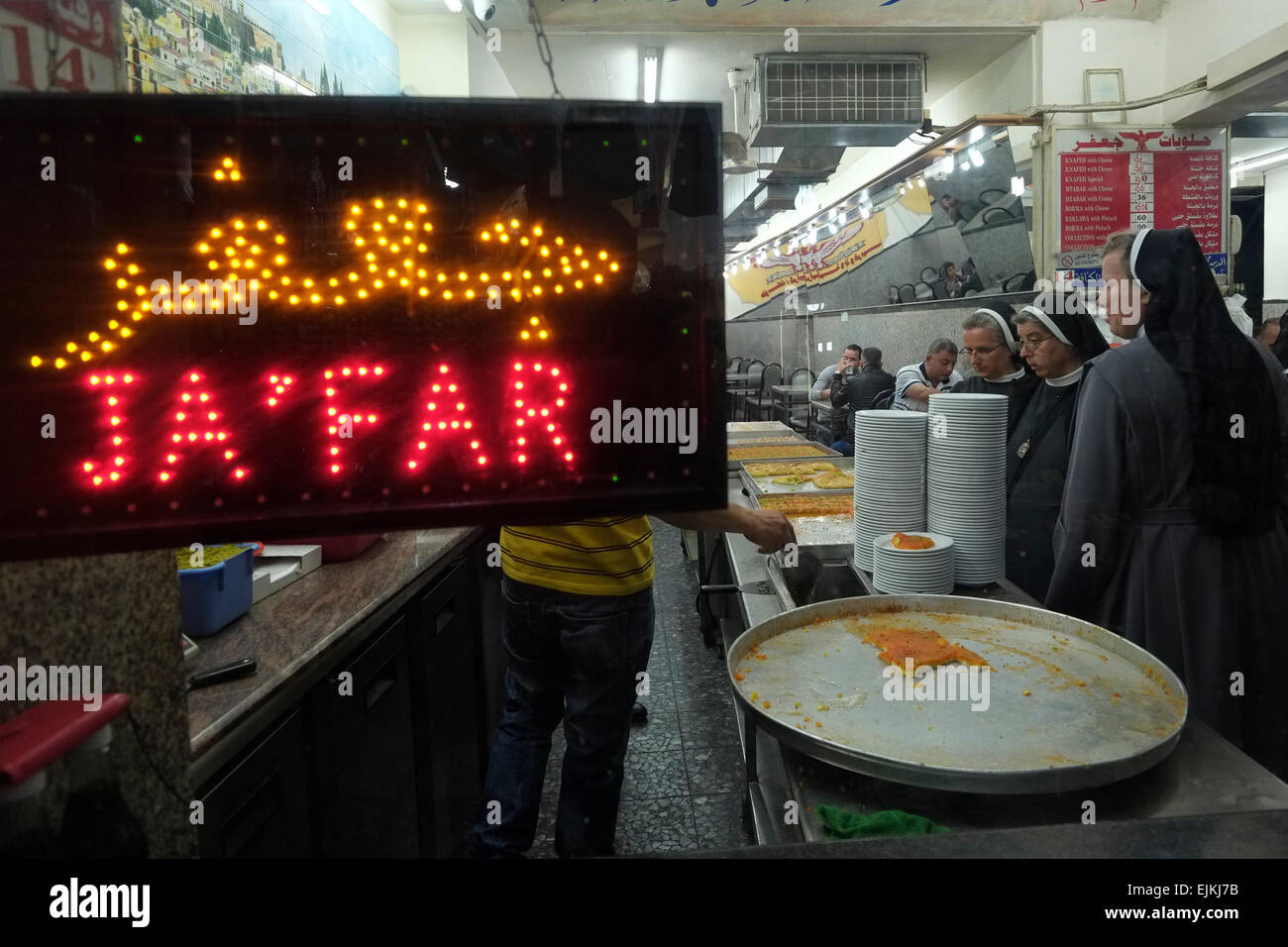 Katholische Nonnen am Ja'far eine muslimische Gebäck-Shop Verkauf von Baklava, Kanafeh und andere Backwaren in Beit Habad auch Khan az Zait Straße in das muslimische Viertel Altstadt Ost-Jerusalem Israel Stockfoto