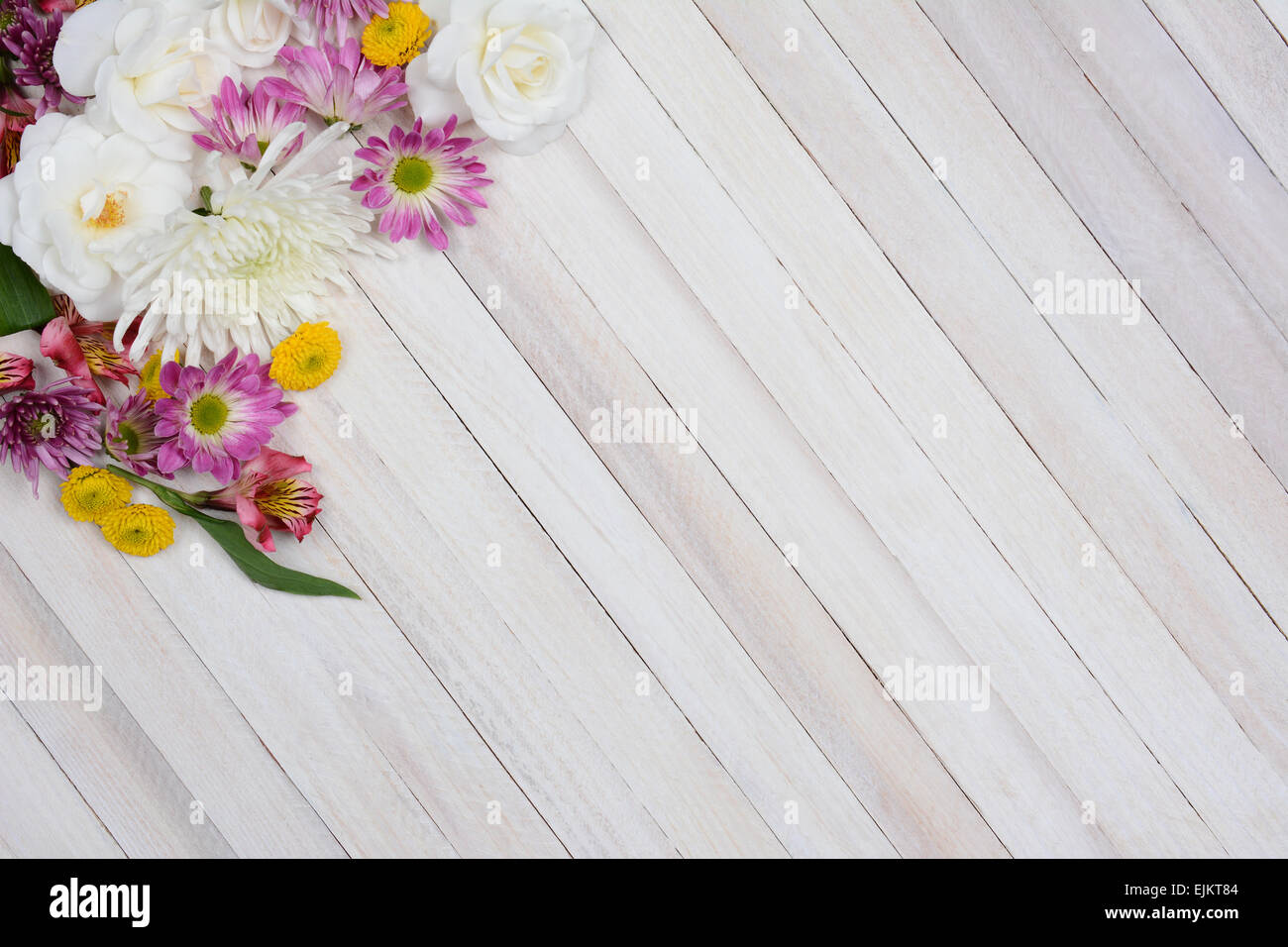 Hohen Winkel Schuss einen Blumenstrauß in der oberen linken Ecke des Rahmens. Bunte Frühlingsblumen Zeit auf einem rustikalen weißen Holz Stockfoto
