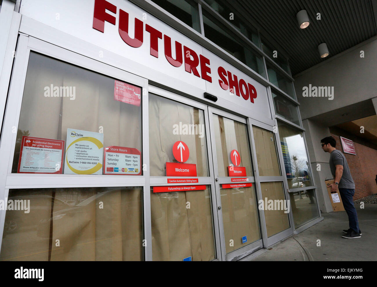 Vancouver, Kanada. 28. März 2015. Ein Bewohner sieht kurzfristig vor einem geschlossenen Future Shop-Filiale in Richmond, Kanada, 28. März 2015. Am besten kaufen Canada Ltd. am Samstag angekündigt, dass es beschlossen, 66 131 Future Shop-Elektronik-Filialen zu schließen und den Rest des Landes konsolidiert. Als der größte kanadische Einzelhändler von Computer und Unterhaltungselektronik Future Shop wurde 1982 gegründet und wurde im November 2001 von der US-Verbraucher-Elektronik-Store-Kette Best Buy für 580 Millionen US-Dollar übernommen. © Liang Sen/Xinhua/Alamy Live-Nachrichten Stockfoto