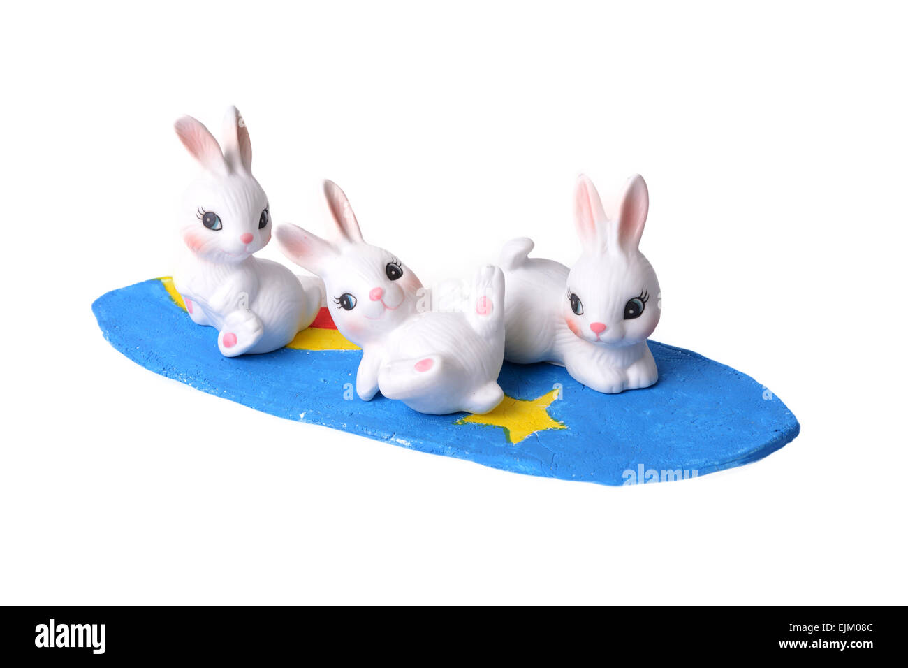 Drei kleine Kaninchen spielen Surfbrett auf weißem Hintergrund. Stockfoto