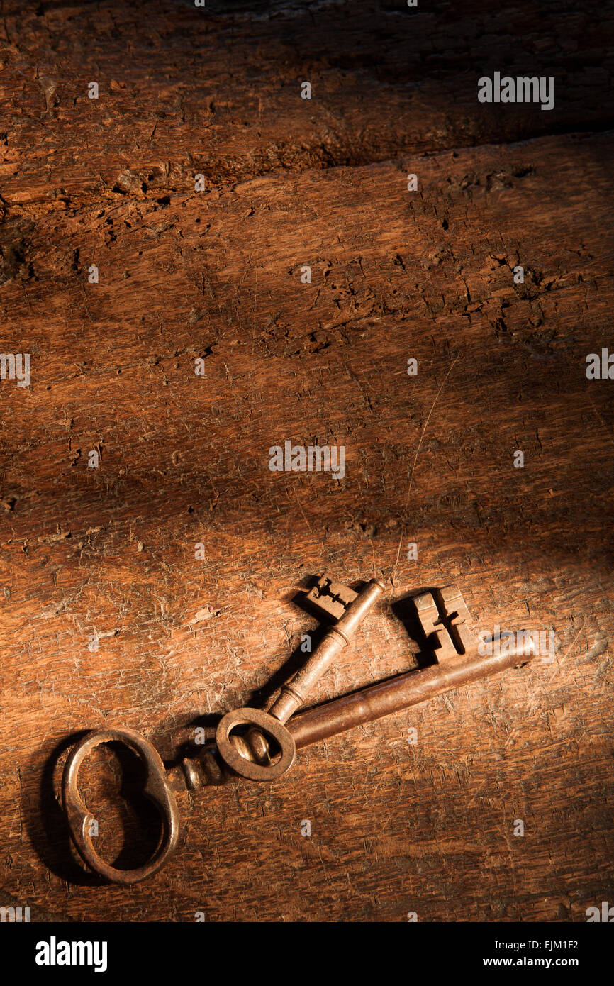 Sehr alte Holzoberfläche mit rostigen Schlüssel und Schattenspiel Stockfoto