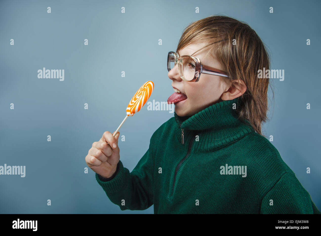 Europäisch anmutende junge von zehn Jahren in Gläsern einen Lutscher lecken Stockfoto