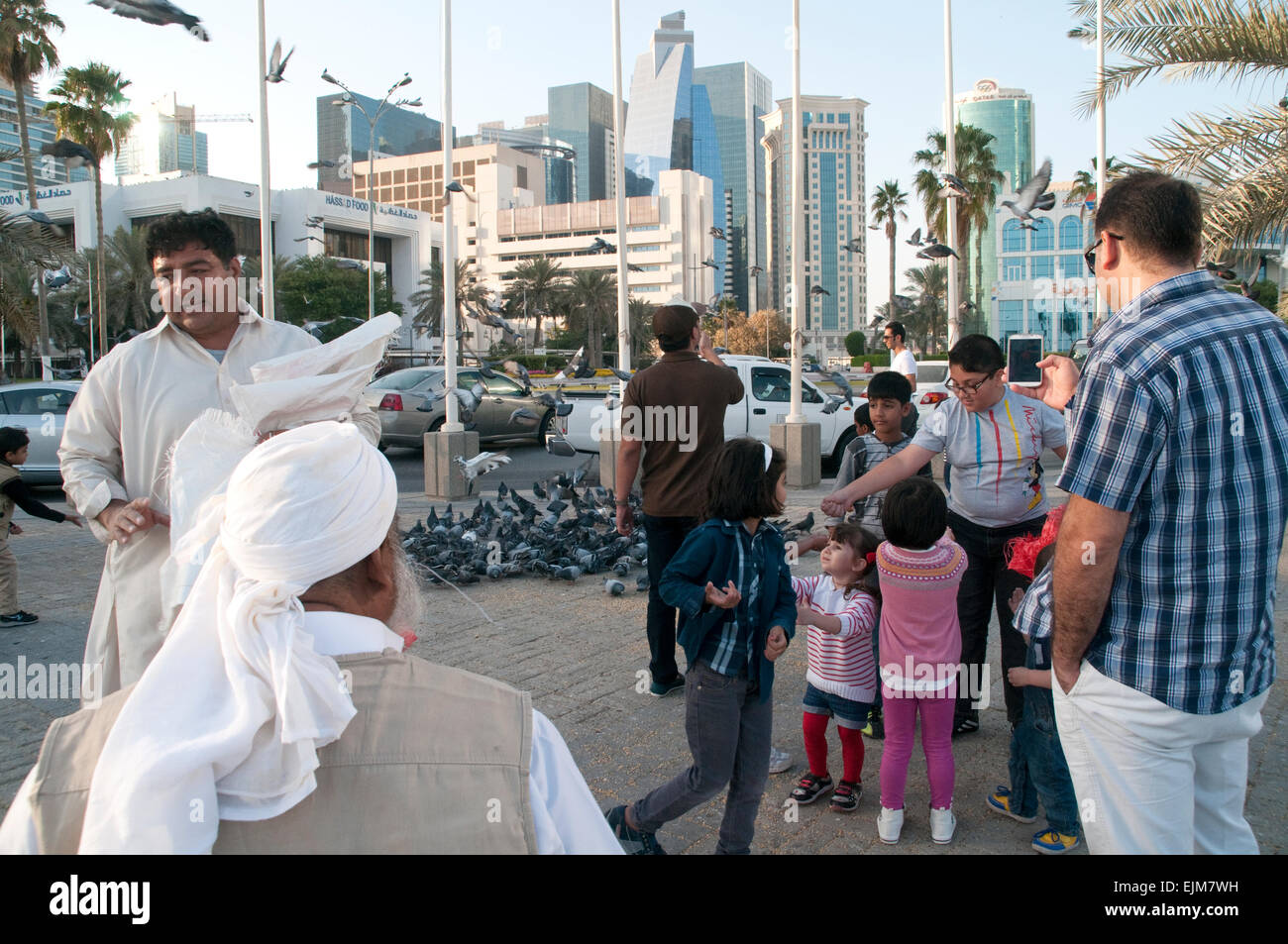 Eine Gruppe von Fußgängern, die sich auf der Straße in der Stadt Doha, im arabischen Golfstaat Katar, versammeln. Stockfoto