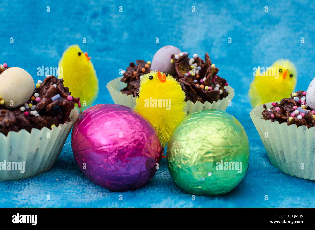 Einzigartige Nahaufnahme einer Ostern-Szene mit Ostereier, Küken und Schoko Cornflakes-Kuchen. Stockfoto