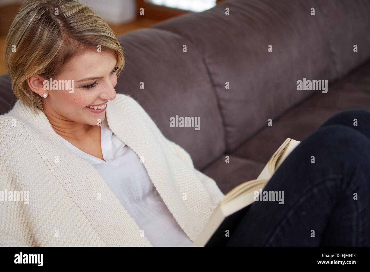 Frau genießen, ein Buch zu Hause liegend auf dem sofa Stockfoto