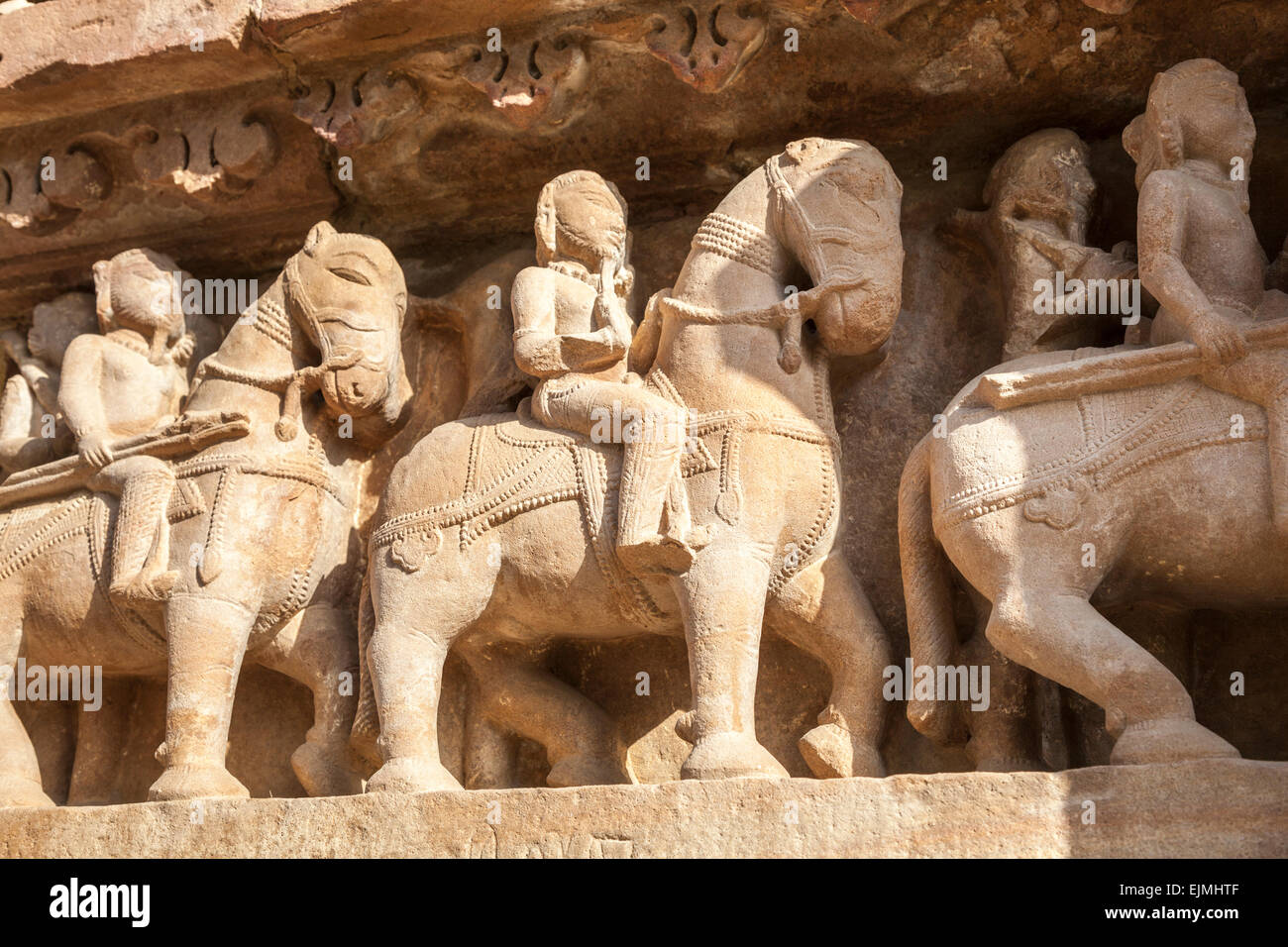 Schnitzereien in einem Hindu Tempel in der westlichen Gruppe in Khajuraho, Madhya Pradesh, Indien Darstellung montiert Krieger auf dem Rücken der Pferde Stockfoto