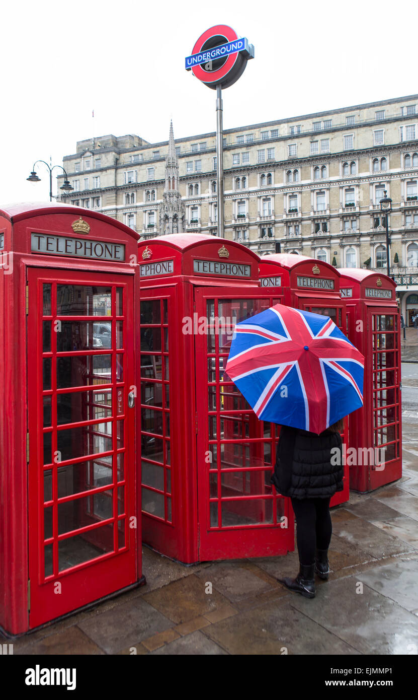 Frau mit Union Jack Regenschirm außerhalb Telefonzellen, London Stockfoto
