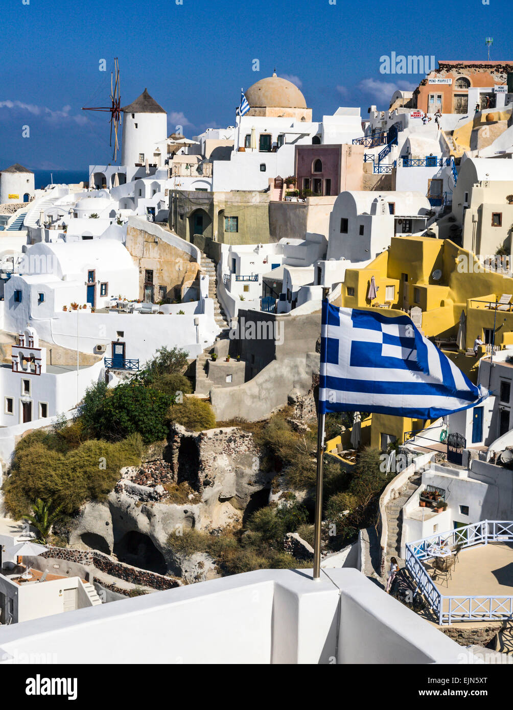 Griechenland, Kykladen, Thira, Santorin, griechische Flagge und die Stadt,  lizenzfreies Stockfoto