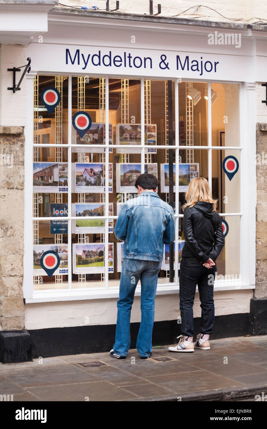 Junges Paar auf der Suche nach Immobilien zum Verkauf in Immobilienmaklern Myddelton & Major in Salisbury, Wiltshire UK im März Stockfoto