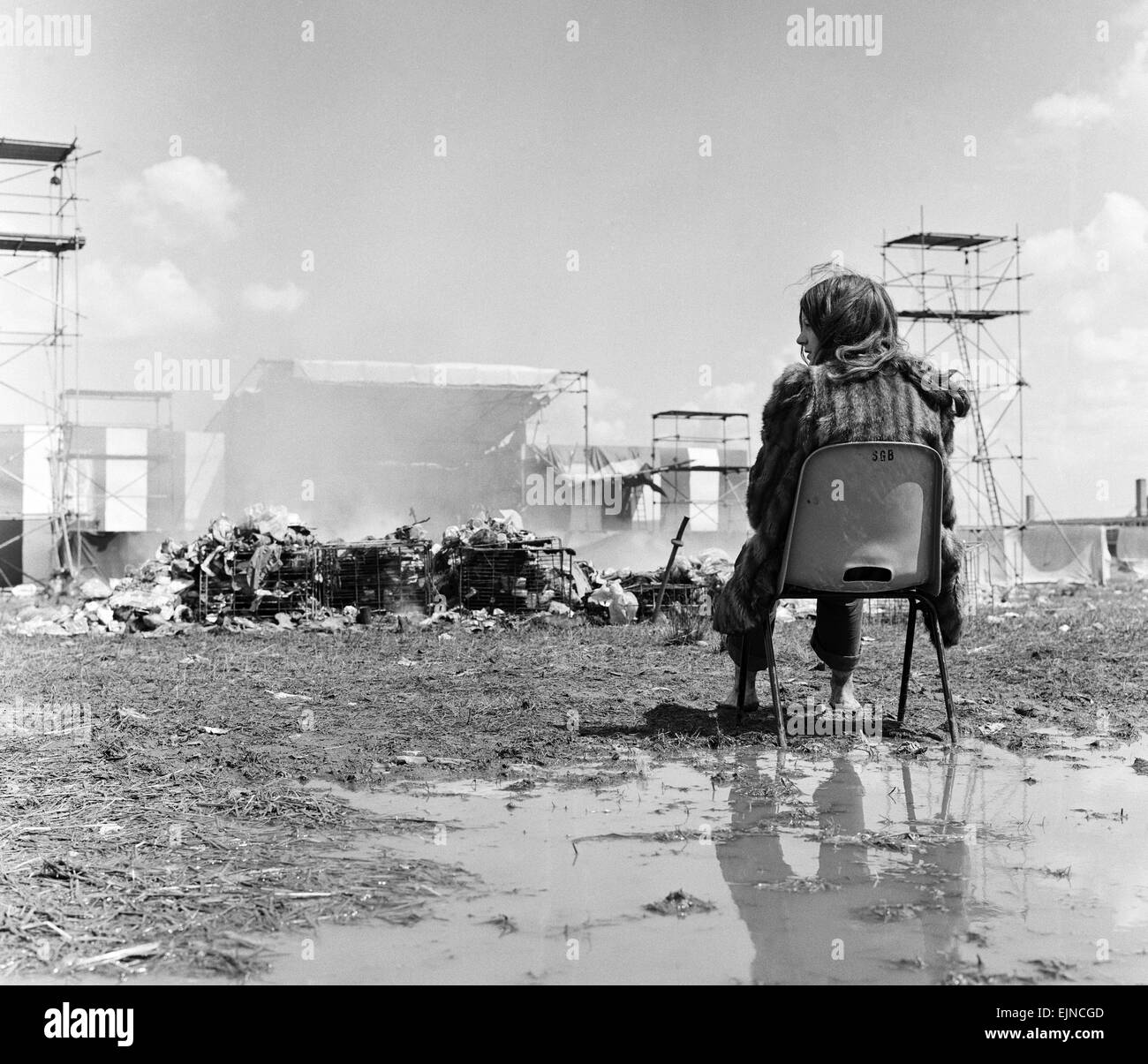 Lesung Pop Festival. Als letztes die Festivalbesucher sitzen mitten unter den Schlamm und den Müll als Arbeiter aufräumen das Chaos am Ende des Festivals. 26. Juni 1971. Stockfoto