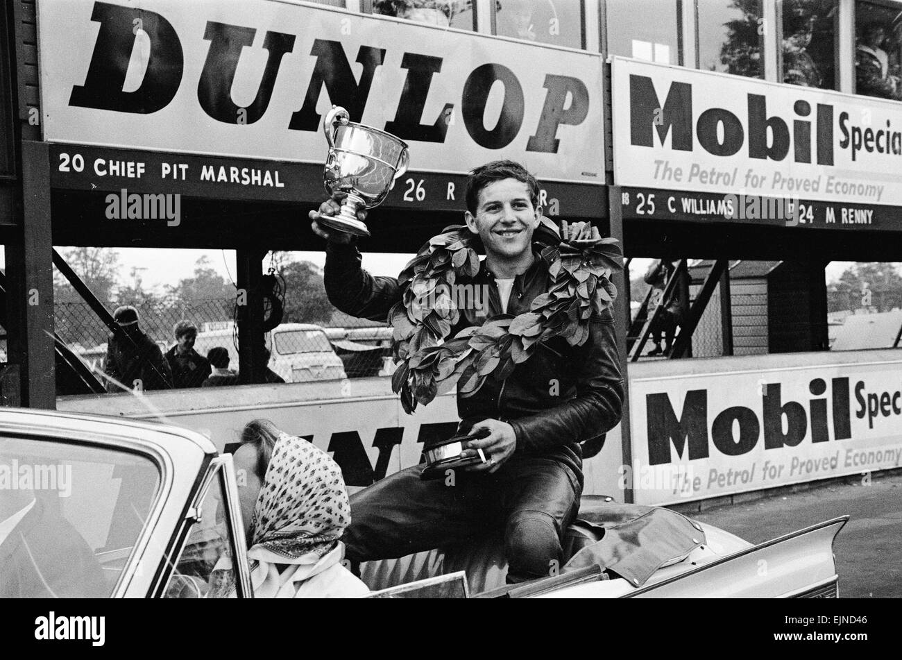 Motorrad Rennen in Oulton Park. Phil Read feiert mit der Trophäe auf eine Ehrenrunde nach dem Gewinn der britischen Junior Championship Rennen. 7. Juli 1963. Stockfoto