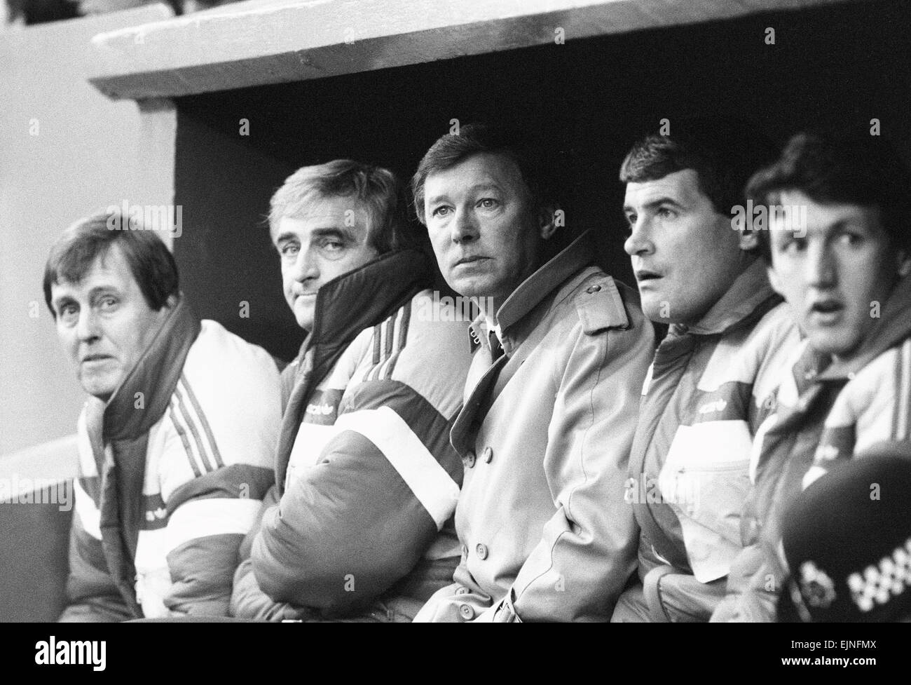 Manchester United-Trainer Alex Ferguson sitzt in der Einbaum mit Trainerstab in der League Division One match gegen Charlton Athletic auf dem Talboden. Das Spiel endete mit einem torlosen Remis. 7. Februar 1987. Stockfoto