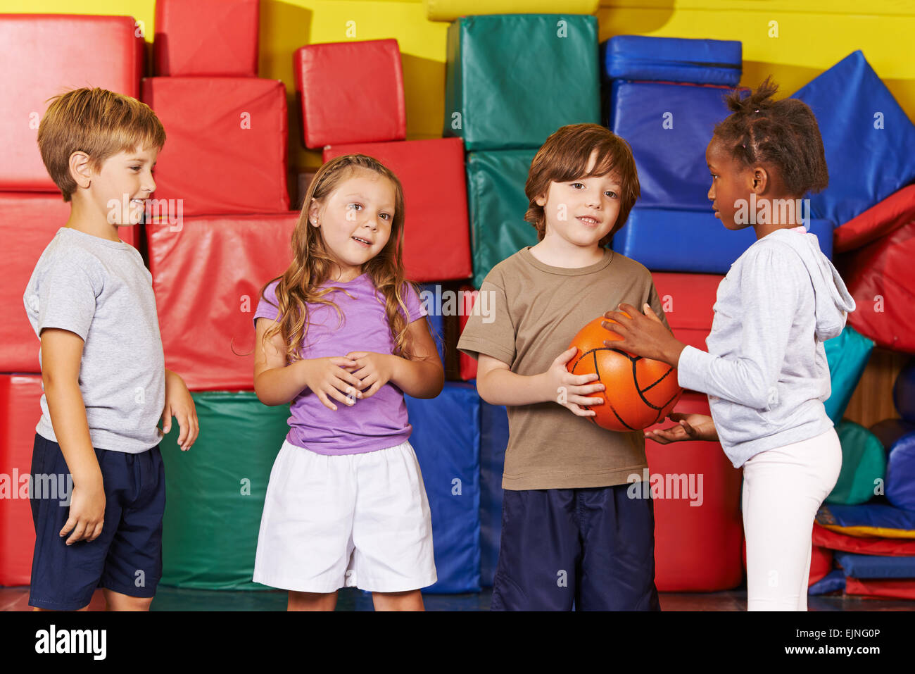 Kinder spielen mit einem Ball in die Turnhalle des Kindergartens Stockfoto