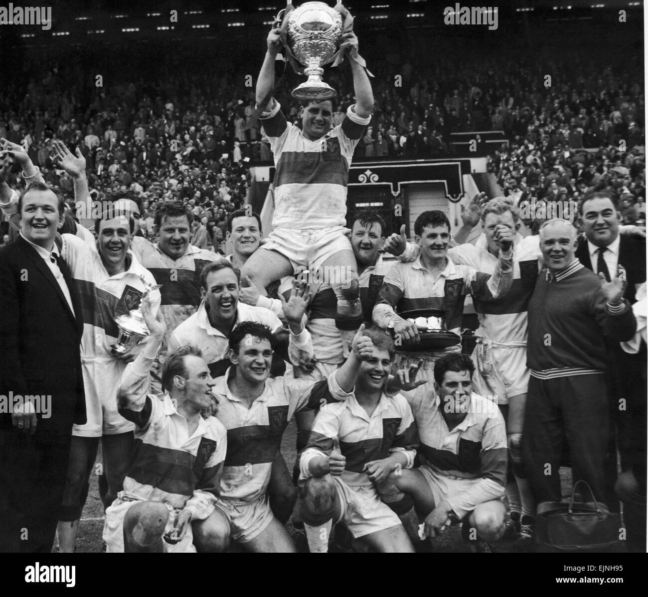 Felsigen Turner der Wakefield Trinity-Kapitän wird mit der Trophäe geleitet, nachdem sein Team gewann die Rugby League Cup gegen Huddersfield 12-6 im Wembley-Stadion. 12. Mai 1962 Stockfoto