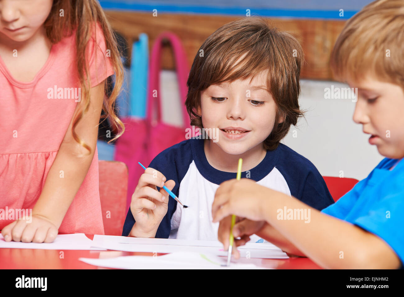 Kinder malen Bilder mit Wasserfarbe im Kunstunterricht in der Grundschule Stockfoto