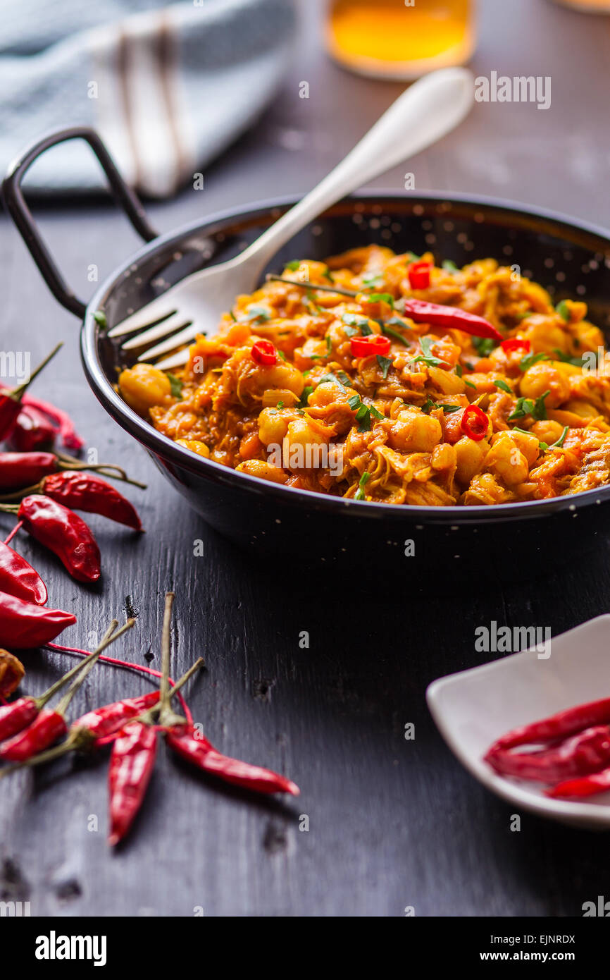 indischer Chickencurry mit Erbsen und Paprika auf Pfanne Stockfoto