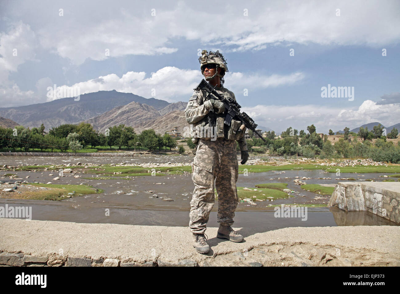 US Army Staff Sgt Michael Cruz von Cortland, N.Y., steht am Ufer des Flusses Pech während einer Patrouille durch die Straßen von Asadabad Stadt in der Provinz Kunar, Afghanistan, Aug. 19. Cruz ist mit dem 1. Bataillon, 32. Infanterie-Regiment, 3rd Brigade Combat Team, 10th Mountain Division, die derzeit als Teil der Task Force Mountain Krieger Staff Sgt. Andrew Smith großen Dawgs Suche nach Antworten dienen wird bereitgestellt, Freunde finden Stockfoto