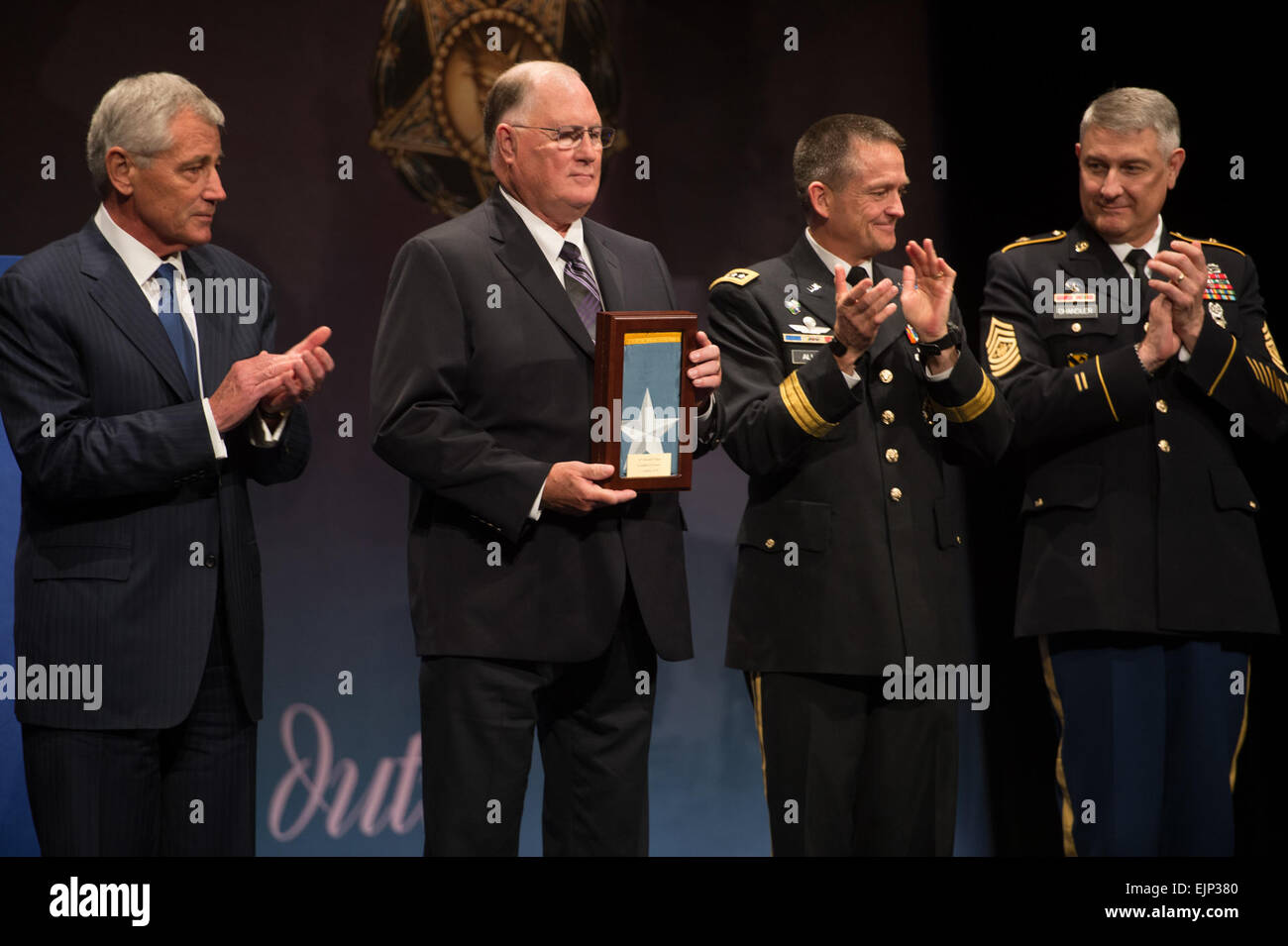 Dr. Bill Sloat akzeptiert die posthume Medal Of Honor-Flagge im Namen seines Bruders Spc. 4 Donald P. Sloat als Verteidigungsminister Chuck Hagel, Armee Vice Chief Of Staff General Daniel B. Allyn und Sgt. Major der Armee Raymond F. Chandler während einer Pentagon Halle der Helden Induktion Zeremonie, 16. September 2014 applaudieren.  Sloat erhielt die Medal Of Honor postum im Weißen Haus Sept. 15, für seine Taten in Vietnam, 1970.   Staff Sgt Bernardo Fuller Stockfoto