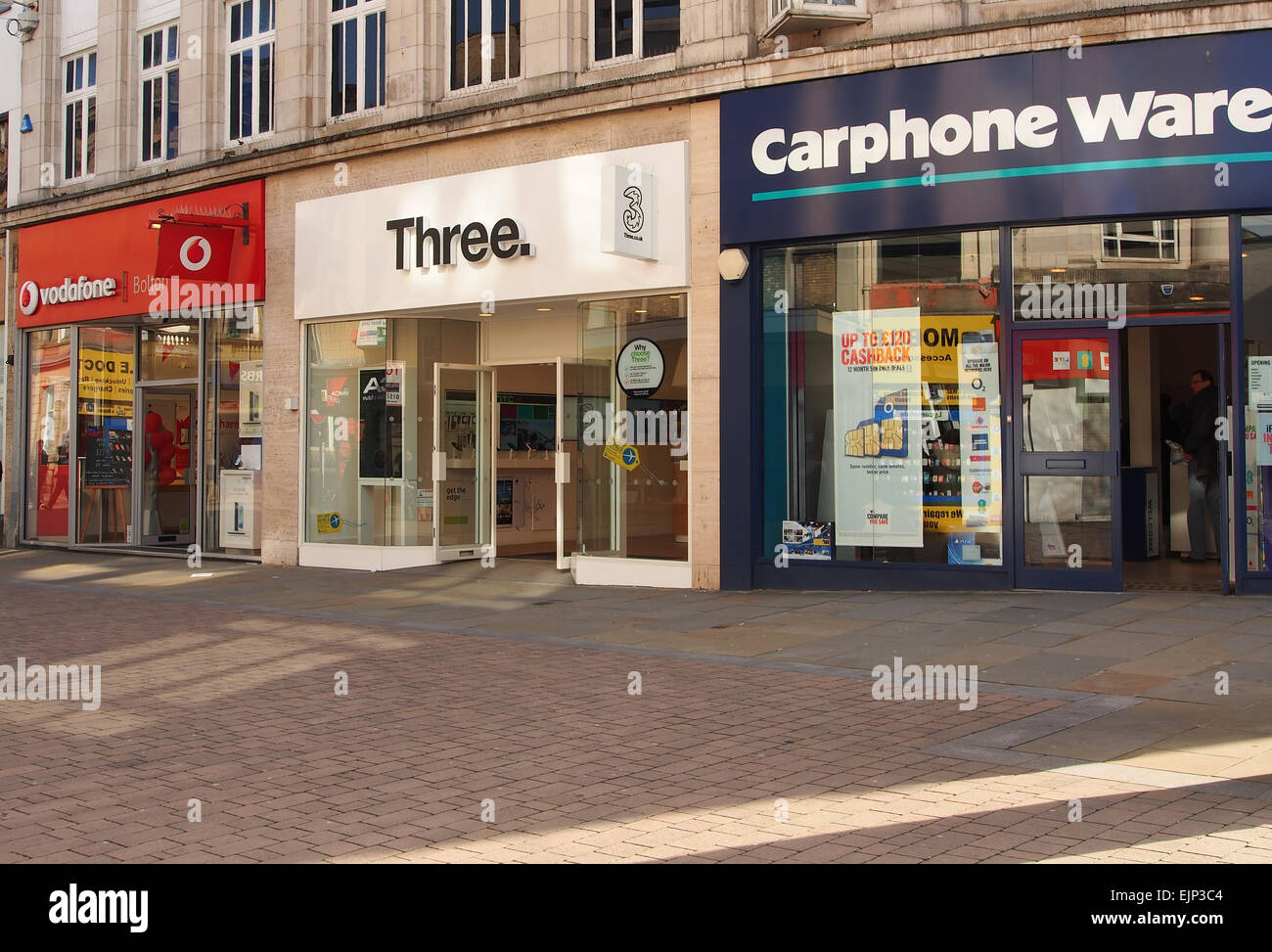 Läden, die Handys - Vodafone, drei und Carphone Warehouse alle zusammen auf einem Bolton Street Lancashire, UK. Stockfoto