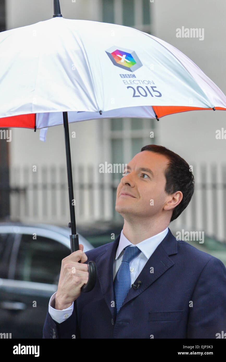 Whitehall, London, UK. 30. März 2015. Kanzler George Osborne Unterstände unter einem Regenschirm vor seinem Interview mit Huw Edwards an der Downing Street. Bildnachweis: Matthew Chattle/Alamy Live-Nachrichten Stockfoto