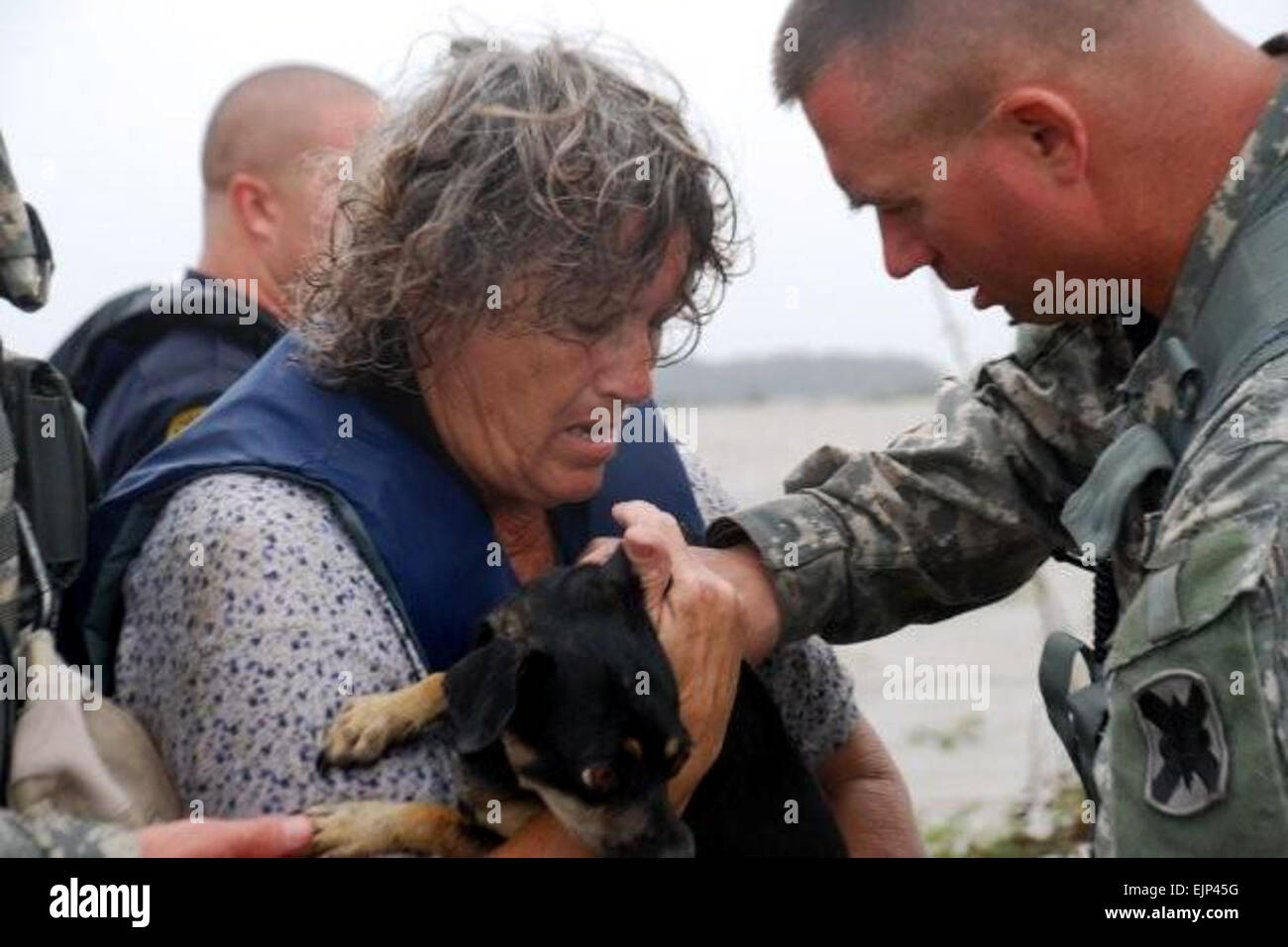 Army Command Sergeant Major Ken Wagner, von der Louisiana Nationalgarde 256th Infantry Brigade Combat Team, hilft Mary Louise Fowler mit ihrem Hund, Erdnuss, während eine Evakuierung in der Nähe von Hackberry, Louisiana, 13. September 2008. Maria und ihr Mann wurden von der örtlichen Polizei von ihrem Boot gerettet, nach seiner Flucht aus ihrer Heimat in der Folge von Überschwemmungen durch Hurrikan Ike. Truppen der Nationalgarde unterstützen Hurrikan Hilfsmaßnahmen.  Rebekah L. Malone. Stockfoto