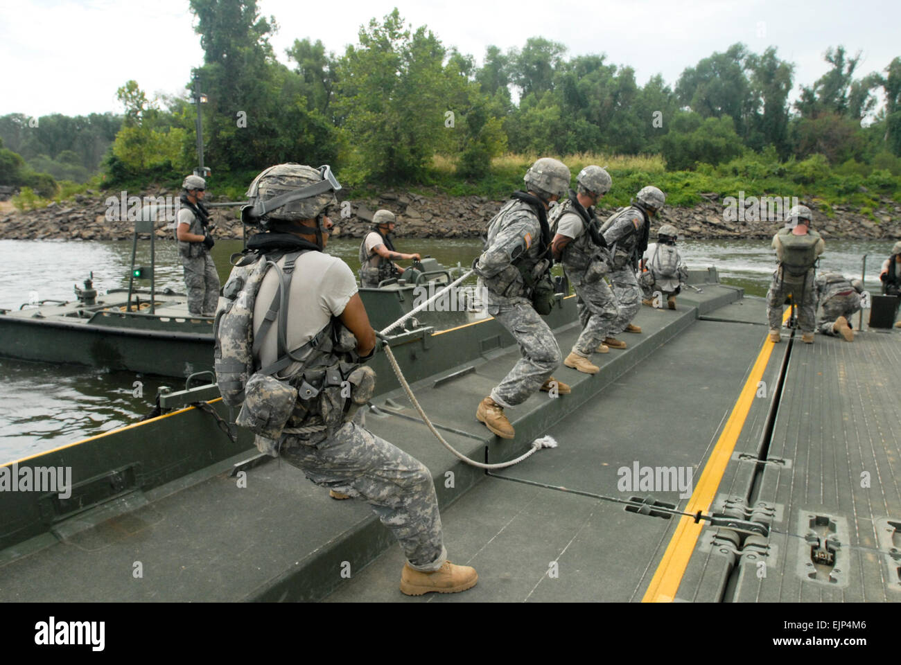 US Army Reserve-Soldaten von den 652nd Ingenieur-Unternehmen mit dem Sitz in Hammond, Wisconsin, USA, entfernen Sie Spannung in Brücke Buchten vor dem trennen sie am Arkansas River im Rahmen einer Fortbildungsveranstaltung am Fluss Angriff 2011 in Fort Chaffee, Arkansas, Juli 26. Fluss-Angriff gipfelte mit dem Bau einer schwimmenden verbesserte Menüband-Brücke über den Arkansas River. Stockfoto