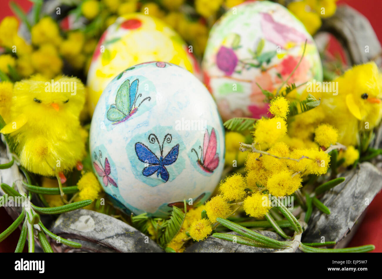 Handgemalte Decoupage Easter Egg auf Holzoberfläche mit einer Frohe Ostern-Karte und zwei Kaninchen Spielzeug Stockfoto