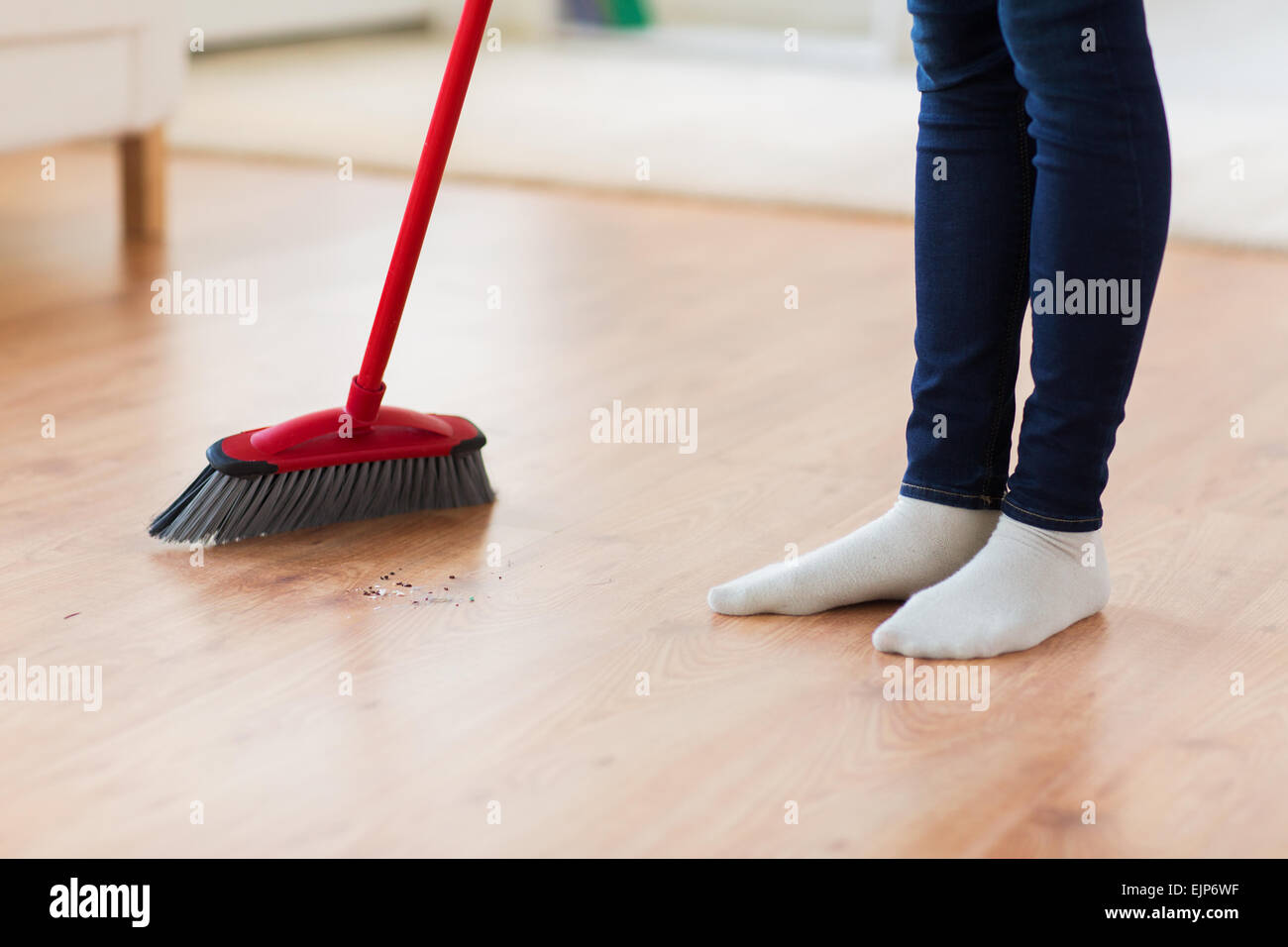 Nahaufnahme von Frau Beine mit Besen fegt Stock Stockfoto
