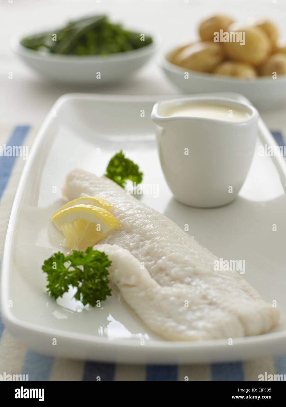 Einfach gekochtem Fischfilet mit Zitrone Petersilie und separate Bechamel-Sauce und Gemüse Stockfoto