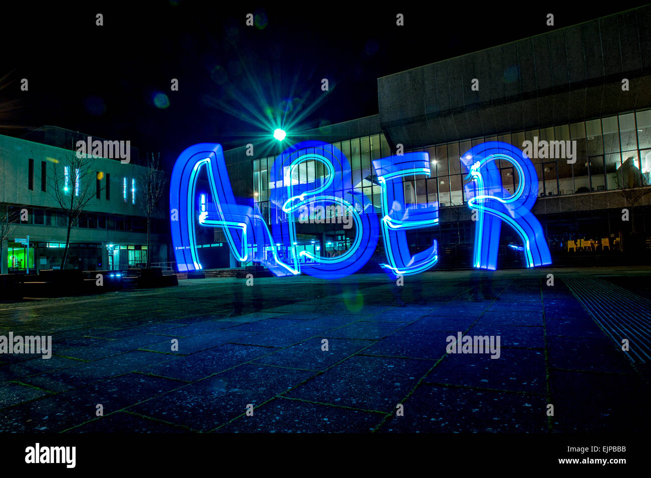 Lightbombing / Licht-Malerei - das Wort "ABER" in Licht außerhalb Aberystwyth Arts Centre in der Nacht Wales UK gemalt Stockfoto