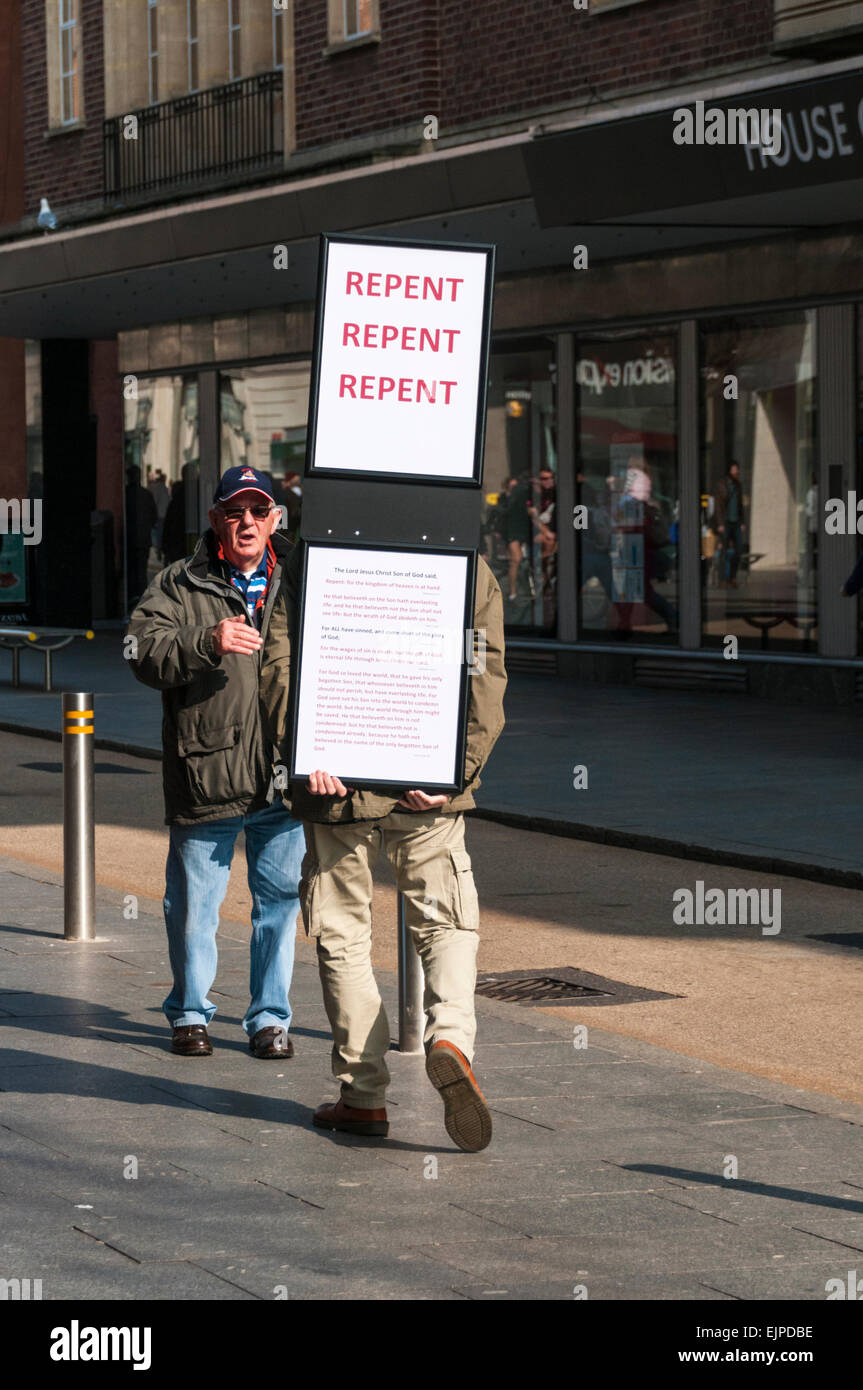 Straßenprediger mit einem bereuen Schild Gespräch mit einem Mann in Exeter Stadtzentrum Stockfoto