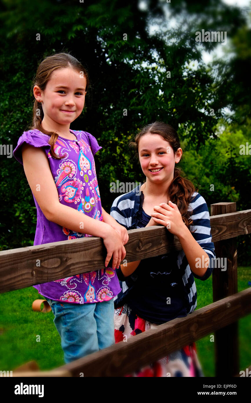 Zwei glückliche Schwestern Spaß in einem Garten hinter dem Haus in North County Dublin Irland. Stockfoto