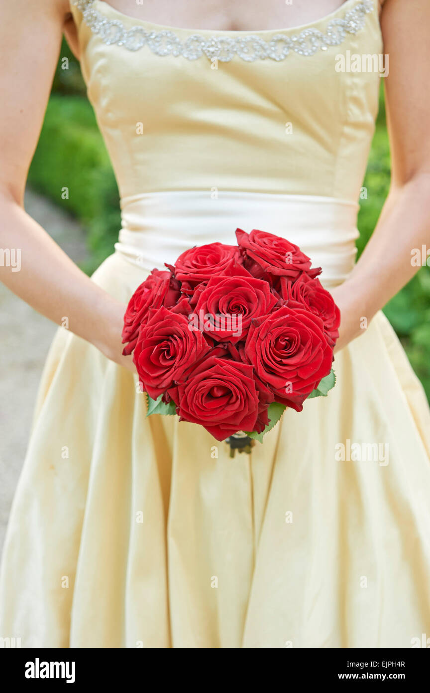 Brautstrauß von roten Rosen und goldenes Kleid von Glauben Caton Barber von  einem gestylten Hochzeit-Shooting im Owlpen Manor Stockfotografie - Alamy