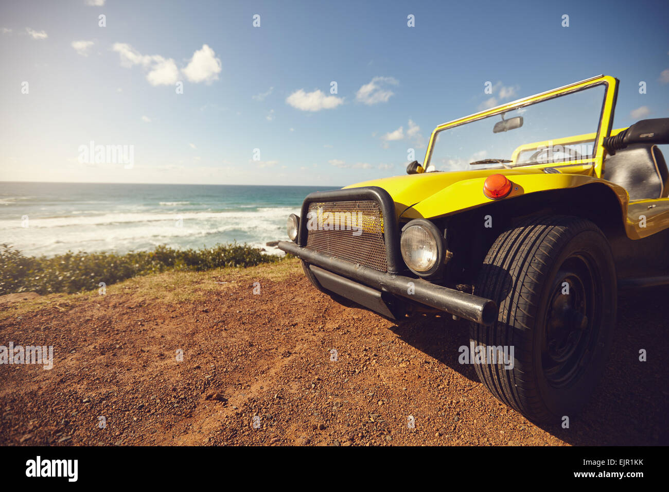 Kleine Dünen-Buggy Auto in schöner Landschaft. Gelbes Auto gegen Meer und blauer Himmel an einem Sommertag mit Exemplar. Stockfoto