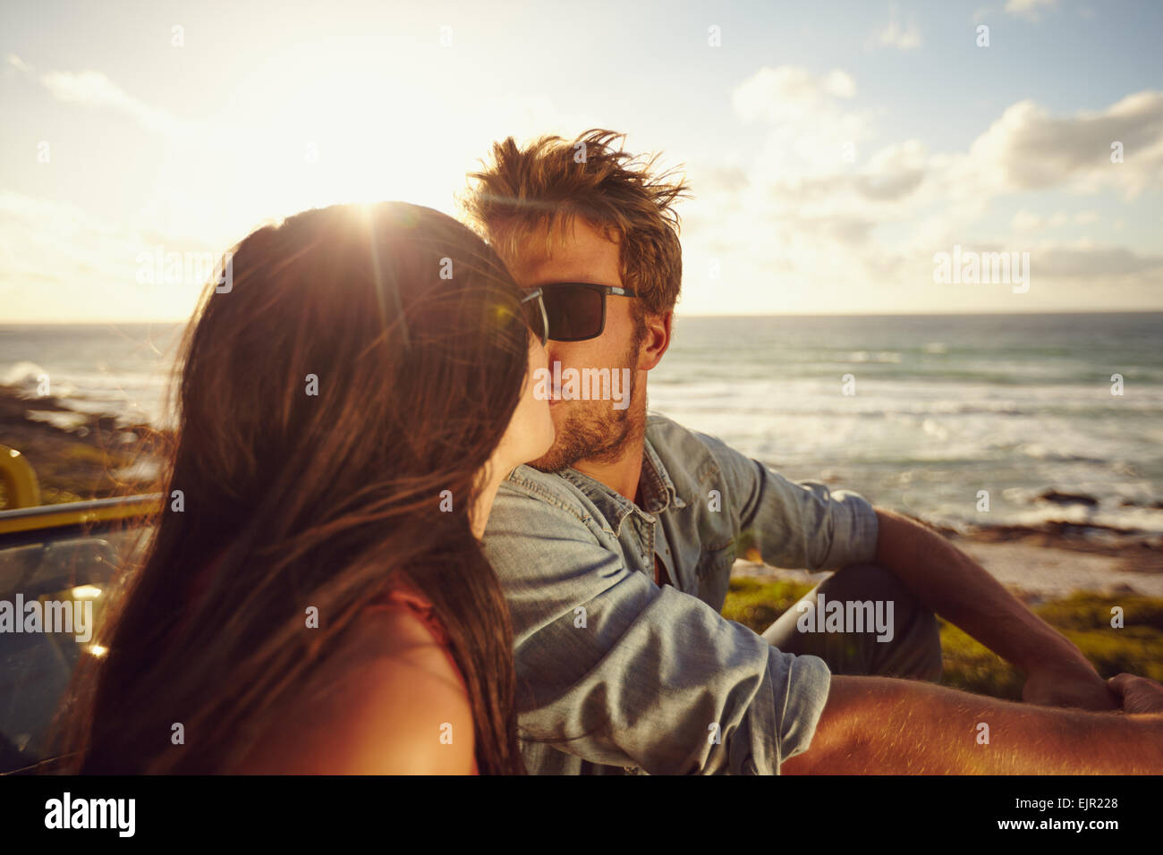 Liebevolle junge Paar küssen. Junges Liebespaar mit Meer im Hintergrund. Romantisch zu zweit im Sommerurlaub. Stockfoto
