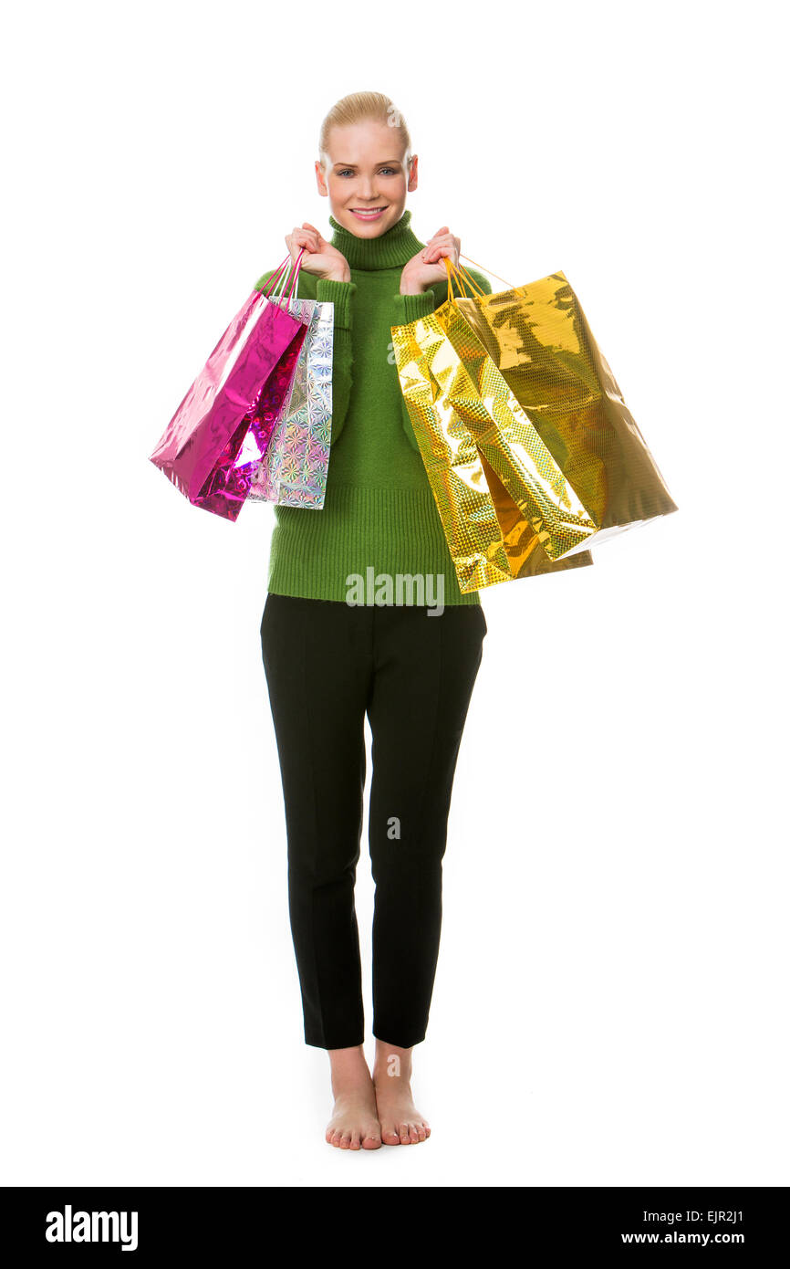 blonde Frau Geschenk Tragetaschen lächelt und schaut in die Kamera Stockfoto
