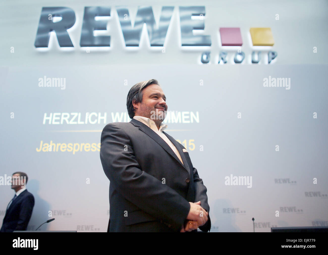 Köln, Deutschland. 31. März 2015. Alain Caparros, Vorstandsvorsitzender der REWE Group, steht vor dem REWE-Logo während des Konzerns Bilanzpressekonferenz in Köln, 31. März 2015. REWE Group profitiert von seiner blühenden Supermarkt-Geschäft in Deutschland letztes Jahr. Foto: OLIVER BERG/Dpa/Alamy Live News Stockfoto