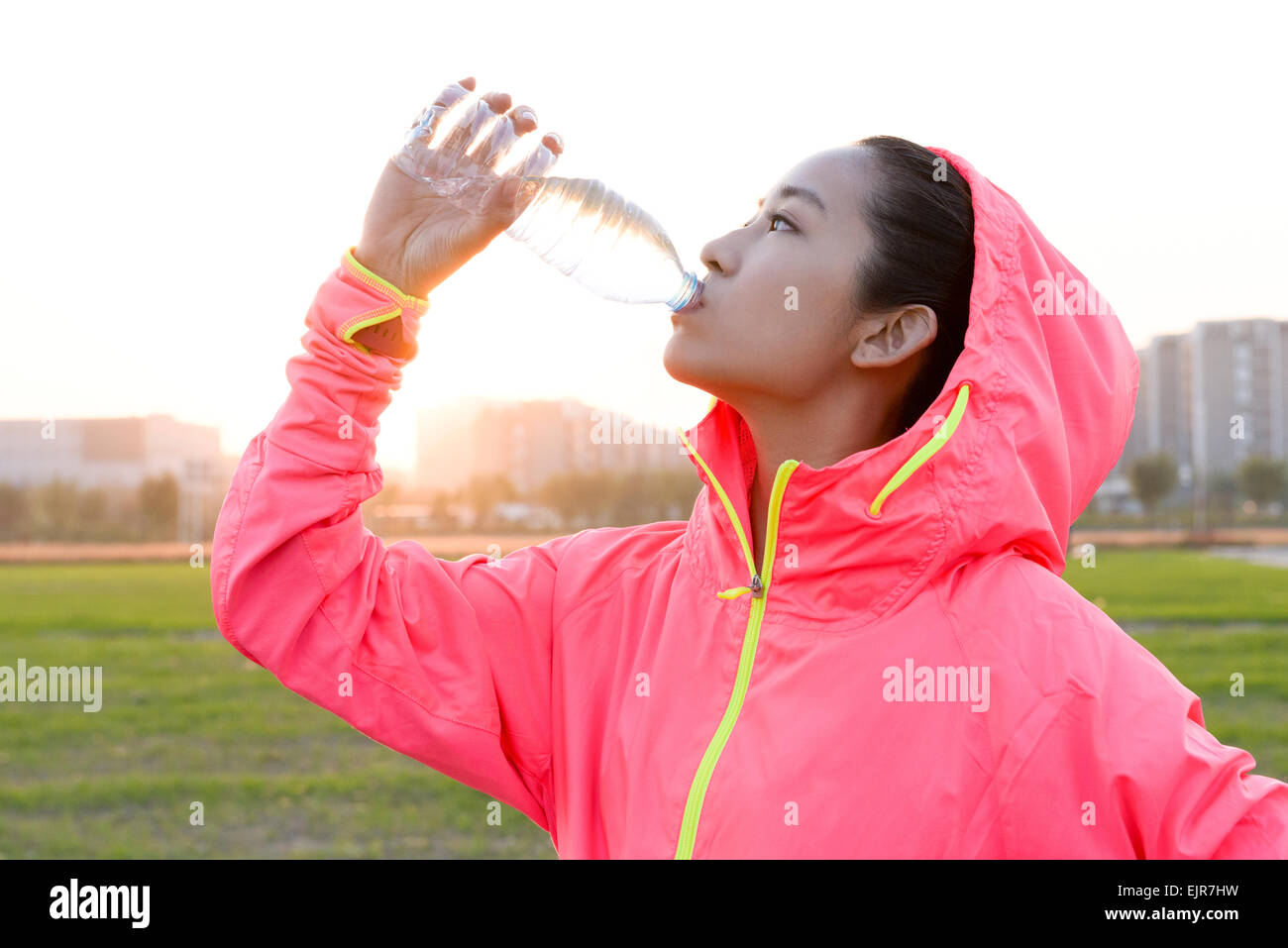 Junge Frau Trinkwasser während des Trainings Stockfoto