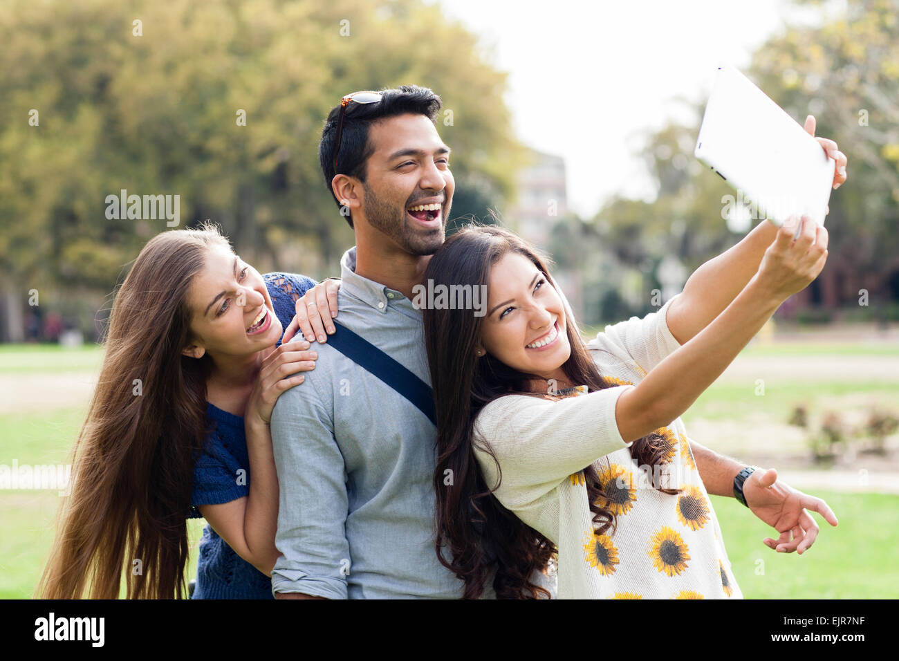 Lächelnden Freunde fotografieren mit digitalen Tablet im park Stockfoto