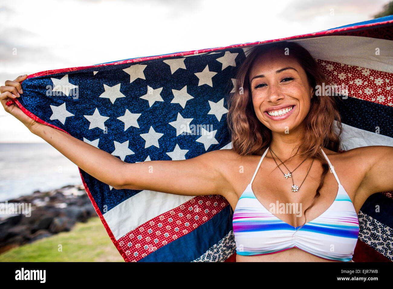 Frau stehend unter amerikanischer Flagge quilt Stockfoto